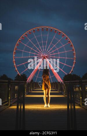 Anonyme weibliche Touristen auf beleuchteten Pier mit glühenden Hintergrund Riesenrad in Montreal Stockfoto