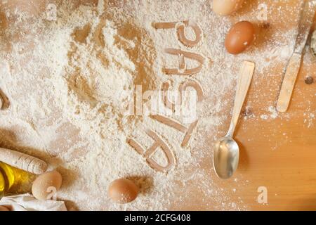 Draufsicht der Inschrift Pasta mit Finger auf Holz geschrieben Küchentisch mit Mehl mit Olivenöl Eier und bedeckt Küche Utensil Lokalisierung auf dem Tisch Stockfoto