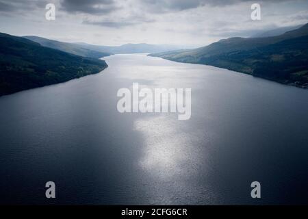 Mondlicht leuchtet auf See Wasser umgeben von Bergen Stockfoto