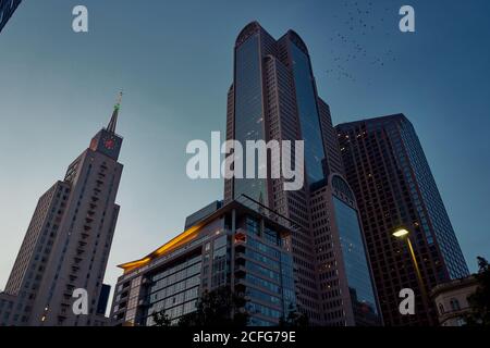 Von unten moderne Wolkenkratzer mit blauem Himmel im Hintergrund bei Dämmerung in Dallas, Texas, USA Stockfoto