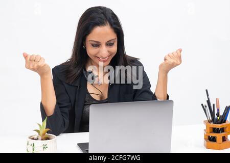 Portrait einer professionellen indischen Geschäftsfrau, die von ihrem Computer aus arbeitet, Freiberuflerin, Arbeit von zu Hause, lächelnde Geschäftsfrau, die Hand winkt. Stockfoto