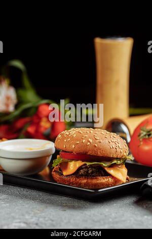 burger mit Schnitzel, Käse und Tomaten. Mit pommes Frites und Burger-Sauce Stockfoto