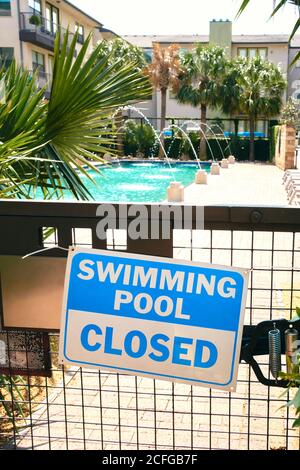 Geschlossenes Schild mit Warnaufschrift auf Gitter Tor in der Nähe platziert Swimmingpool Stockfoto