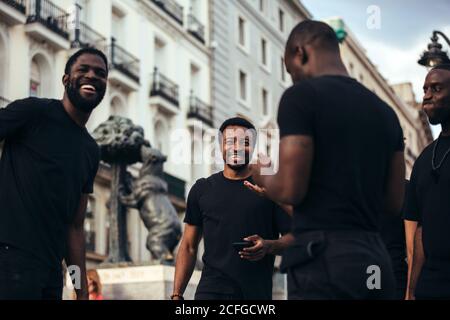 Glückliche schwarze Rennfreunde hängen in der Stadt an einem Sommertag. Stockfoto