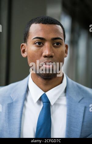 Nahaufnahme Porträt von gutaussehenden ernst afroamerikanischen Mann in trendigen blauen Anzug und Krawatte Blick weg pensive. Stockfoto