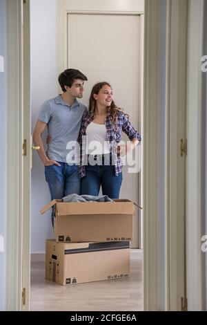 Junges Paar Umzugskartons in neue leere Wohnung mit Tür geöffnet Stockfoto