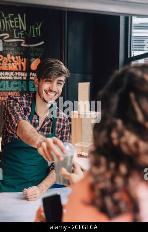 Barkeeper überreicht einem Gast Getränke Stockfoto