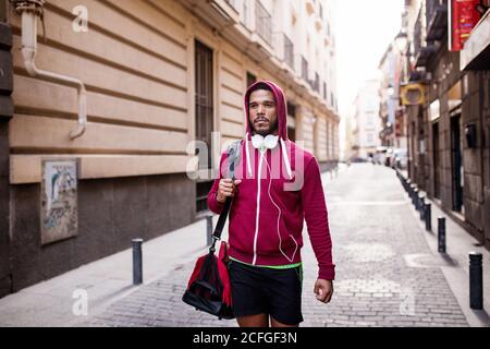 Junger Mann, der in Sportkleidung durch die Stadt läuft Stockfoto