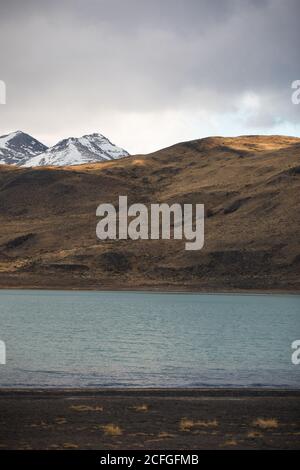 Schöne Landschaft des Flusses im Tal gegen neblige schneebedeckte Berge Stockfoto