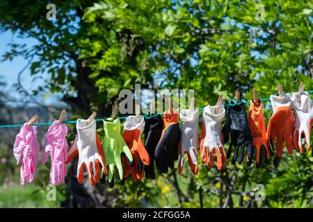 Handschuhe trocknen am Seil im Hinterhof Stockfoto