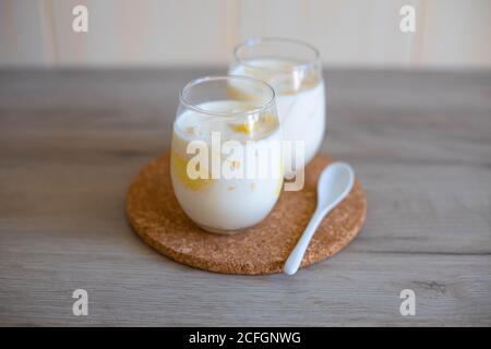Köstliches Milchdessert mit Melonenstücken in Glasgläsern Auf einem Holztisch Stockfoto