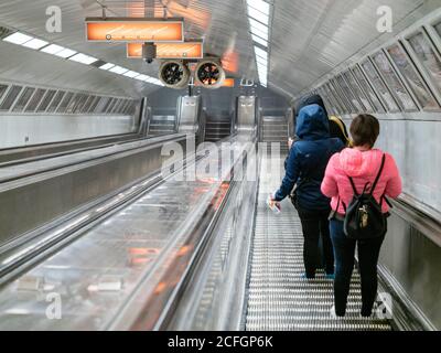 Tiefe U-Bahn in Budapest: Zugfahrer nehmen eine sehr lange Rolltreppe tief unter der Stadt, um das effiziente öffentliche Verkehrssystem in der Stadt Budapest zu fahren. Stockfoto