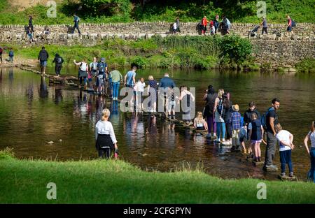 Überqueren Sie die Trittsteine über den Fluss Wharfe in den Yorkshire Dales, England, Großbritannien Stockfoto