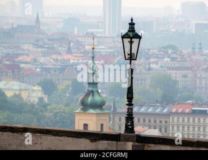 Prager Gaslicht: Ein modernes Gaslicht im Burgviertel mit den Gebäuden und Türmen der Unterstadt als Hintergrund. Stockfoto