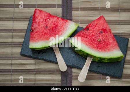 Wassermelonenscheibe auf schwarzer Steinplatte, Eiscreme-Konzept, selektiver Fokus Stockfoto