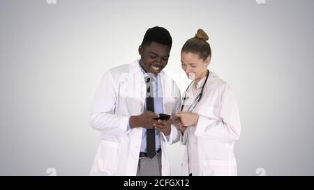 Medizinische Team am Telefon zusammen auf farbverlauf Hintergrund. Stockfoto