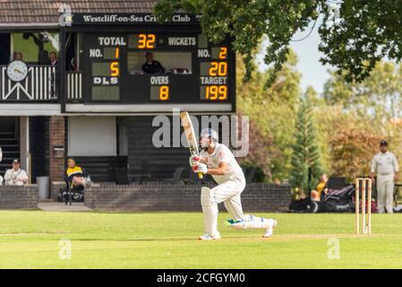 Cricket wird in Chalkwell Park, Westcliff on Sea, Southend, Essex, Großbritannien gespielt. Westcliff on Sea Cricket Club Batsman schlug vor dem Clubhaus Stockfoto