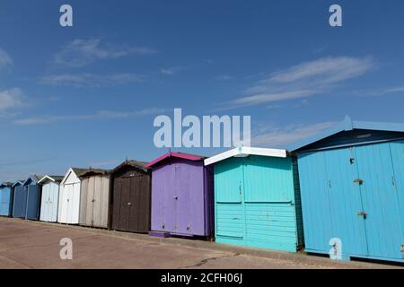 Eine Reihe von bunten Strandhütten in Frinton-on-Sea, Essex. Stockfoto