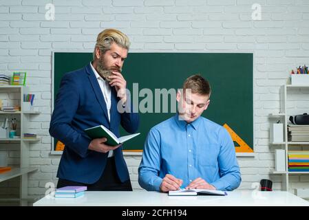 Schüler und Lehrer. Lehrer hilft Schülern bei der Aufgabe, Stockfoto