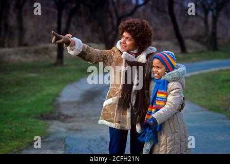 1980 AFROAMERIKANISCHE MUTTER UND TOCHTER IM FREIEN AUF DER LANDSTRASSE TRAGEN WINTER MÄNTEL HÜTE SCHALS HANDSCHUHE LÄCHELND MAMA ZEIGT - KJ9009 PHT001 HARS KLEIDUNG LAND NOSTALGISCH AKTIVEN HERBST PAAR SCHÖNHEIT GEMEINSCHAFT SUBURBAN FARBE MÜTTER ALTE ZEIT BESCHÄFTIGT LEHRE NOSTALGIE ALTE MODE 1 FITNESS JUGENDSTIL KOMMUNIKATION GESUNDE SICHERHEIT TEAMWORK STARK ZUFRIEDEN FAMILIEN FREUDE LEBENSSTIL ELTERNSCHAFT FRAUEN MÄNTEL GESUNDHEIT HAUS LEBEN KOPIE RAUM HALBLANG DAMEN TÖCHTER PERSONEN FÜRSORGLICH SPUR AKTIVITÄT GLÜCK KÖRPERLICH WELLNESS FRÖHLICH ENTDECKUNG STÄRKE AFROAMERIKANER AFROAMERIKANER UND ERHOLUNG Stockfoto