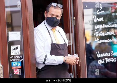 (200905) -- WIEN, 5. September 2020 (Xinhua) -- EIN Kellner mit Gesichtsmaske wird am 5. September 2020 in einem Restaurant in Wien, Österreich, gesehen. Das "Ampelsystem" COVID-19 ist in Österreich offiziell in Betrieb genommen worden, teilte die Regierung am Freitag mit. Aufgrund der anhaltend hohen Zahl an Neuinfektionen, Österreichs drei Großstädte -- Wien, Linz und Graz -- Ebenso wie der Tiroler Landkreis Kufstein leuchten in "gelb" (mittleres Risiko), während der Rest des Landes als "grün" (niedriges Risiko) bezeichnet wird, so eine Pressekonferenz von Bundeskanzler Sebastian kurz und anderer Regierung von Stockfoto