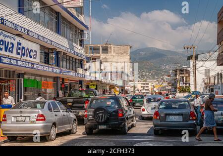 Acapulco, Mexiko - 25. November 2008: Vielbeschäftigter Auto- und Fußgängerverkehr von Autos und Fußgängern in Geschäftseinkaufsstraße, unter blauer Wolkenlandschaft und m Stockfoto