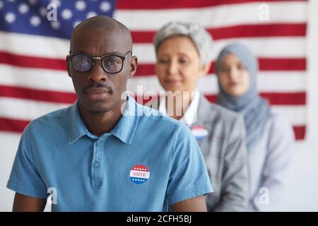 Multiethnische Gruppe von Menschen in Wahlstation am Wahltag, konzentrieren sich auf afroamerikanischen Mann mit ich STICKER auf Kamera, Kopierer Raum GEWÄHLT Stockfoto