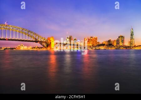 Farbenfroher Sonnenuntergang über dem zentralen Geschäftsviertel von Sydney am Hafen von Sydney in der Nähe der Hafenbrücke. Stockfoto