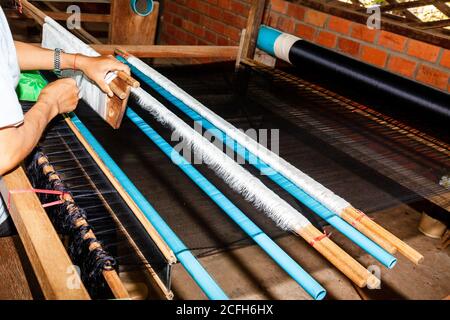 Arbeiten eines Webstuhls, Szene in der Seidenfabrik in Kambodscha. Seide direkt aus den Kokons von Seidenwürmern. Seidenstoff wurde im alten China erfunden und spielte eine Stockfoto