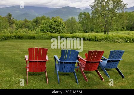 Farbenfrohe Rasenstühle bieten Touristen einen entspannenden Blick auf den Cannon Mountain und Mount Lafayette im Franconia Notch State Park in New Hampshire. Stockfoto