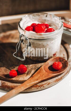 Über Nacht Hafer oder Haferflocken mit Erdbeeren und Jogurt in einem Glas. Holzlöffel zum Essen.gesunde Ernährung, gesundes Lifestyle-Konzept. Stockfoto