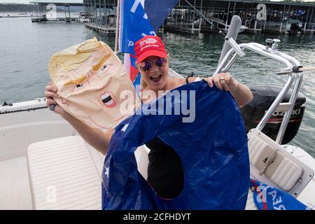 Lakeway, Texas USA 5. September 2020: Eine Bootsfahrerin schmückt ihr Boot mit einem Papiermodell von Präs. Donald Trump, bevor sie an einer Pro-Trump-Bootsparade am Lake Travis teilnimmt, die Hunderte von Wasserfahrzeugen aller Größen anzog. Mehrere Boote wurden überschwemmt oder in den riesigen Wellen versenkt, die von den Wachen der Flottille aufgeworfen wurden, aber es wurden keine Verletzungen gemeldet. Kredit: Bob Daemmrich/Alamy Live Nachrichten Stockfoto