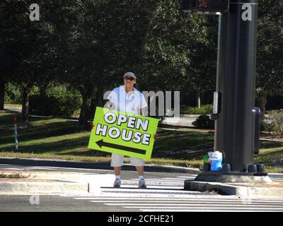 Black minority man holdiing open house sign for new or used or previously own home or house Stockfoto