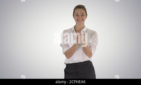 Glückliche junge Geschäftsfrau klatschen Hände auf Gradienten Hintergrund. Stockfoto