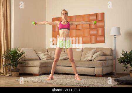 Junge hübsche blonde Frau tut Fitness-Übung zu Hause Stockfoto