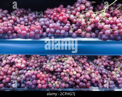 Reife und frische rote Trauben auf dem Obstregal im Supermarkt. Selektiver Fokus. Stockfoto