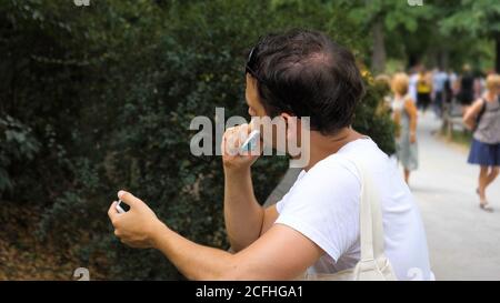 Mann, der Süßigkeiten im Park isst. Stockfoto