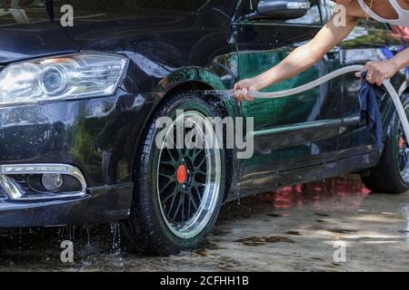 Männliche Hand mit Schaumstoff waschen Auto Rad Reinigung Räder Verwenden Sie Wasser Stockfoto