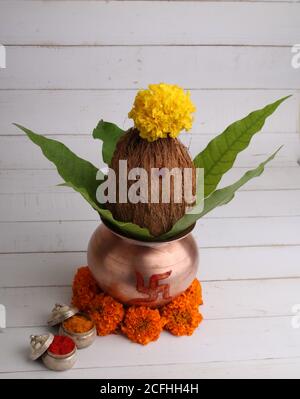 Kupfer kalash mit Kokos- und Mangoblatt mit haldi Kumkum und Blumenschmuck. Unverzichtbar in hindu Puja. Stockfoto