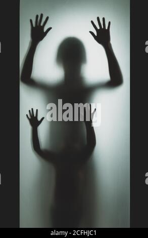 Konzept Schatten von Mutter und Kind hinter dem matten Glas Verschwommener Hand- und Körperfokus Stockfoto