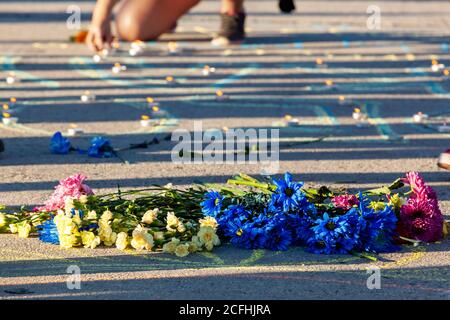 Washington, DC, USA, 5. September 2020. Im Bild: Blumen, die in Erinnerung an Deon Kay gelegt werden, während eine Frau die letzten Kerzen seines Namens auf der Francis Scott Key Bridge während des March for Justice in seinem Gedächtnis entzündet. Deon Kay war ein Teenager, der Anfang der Woche von der Metropolitan (DC) Polizei getötet wurde. Die Tötung ist umstritten, weil die Polizei widersprüchliche Berichte über die Tötung herausgegeben hat. Kredit: Allison C Bailey/Alamy Stockfoto