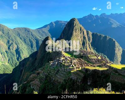 Awe Machu Picchu legendäre verlorene Stadt Inka Reich in Peru, Anden Berge. Majestätische historische Komplex Wahrzeichen, alte Steingebäude, grünes Gras Stockfoto