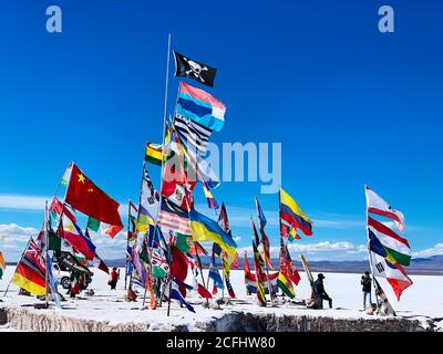 Bunte internationale Flaggen in der weißen, salzhaltigen Wüste Salar de Uyuni, Bolivien. Stockfoto