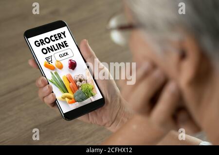 Ältere Frau, die die mobile App verwendet, um Lebensmittel zu bestellen Lebensmittel auf Online-Supermarkt für Lebensmittel Lebensmittelgeschäft Stockfoto