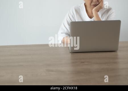Ältere Frau mit Laptop-Computer-Tablet zu Hause Stockfoto