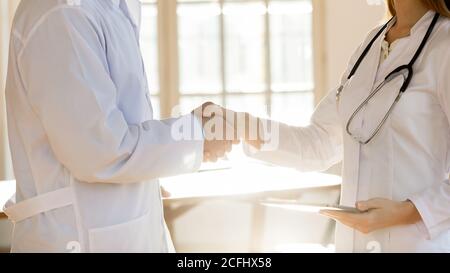 Nahaufnahme zwei Ärzte Kollegen schütteln die Hände, begrüßen, Erfolg feiern Stockfoto