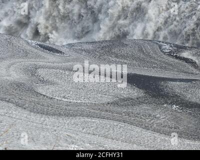 Natursteinherz in der Nähe des mächtigen Wasserfalls Gullfoss in Island. Erstaunliche isländische Natur. Graue Herzform aus Kieselstein. Herzförmiger Stein. Stockfoto