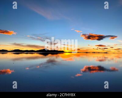 Herrlicher Sonnenuntergang am Salar de Uyuni, Bolivien. Wunderschöner Sonnenuntergang. Gelb-rosa Dämmerung. Atemberaubende Aussicht auf den Salzsee. Meditationsnatur. Stockfoto