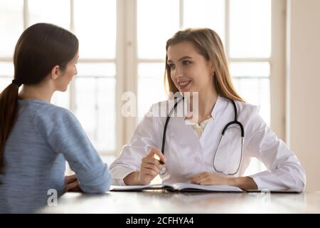 Lächelnd weibliche Arzt Therapeut Beratung Patienten bei medizinischen Termin Stockfoto