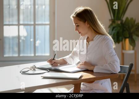 Junge Ärztin Therapeut Dokumente füllen, arbeiten im Büro Stockfoto